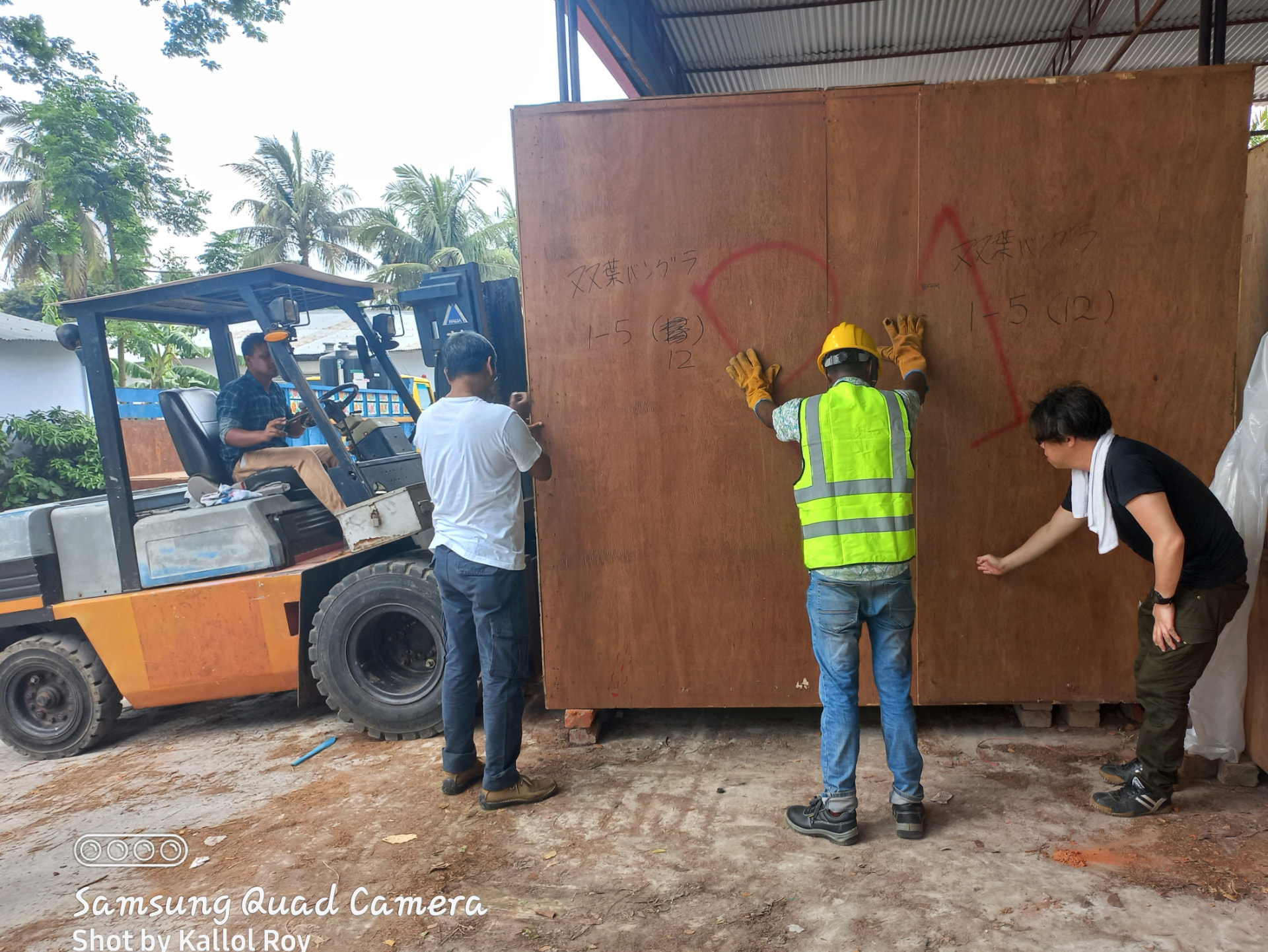 MYM Corporation team handling a Japanese-marked equipment crate during cargo operations